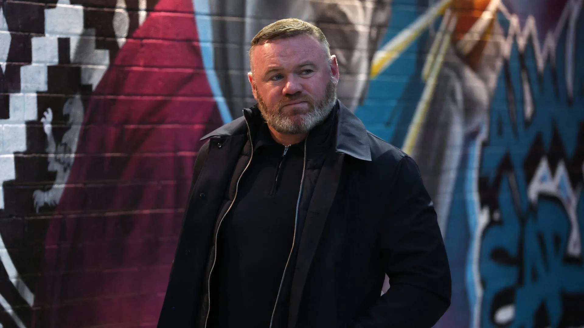 Wayne Rooney đứng trên đường biên chỉ đạo, hình ảnh quen thuộc trong sự nghiệp huấn luyện đầy thử thách.
