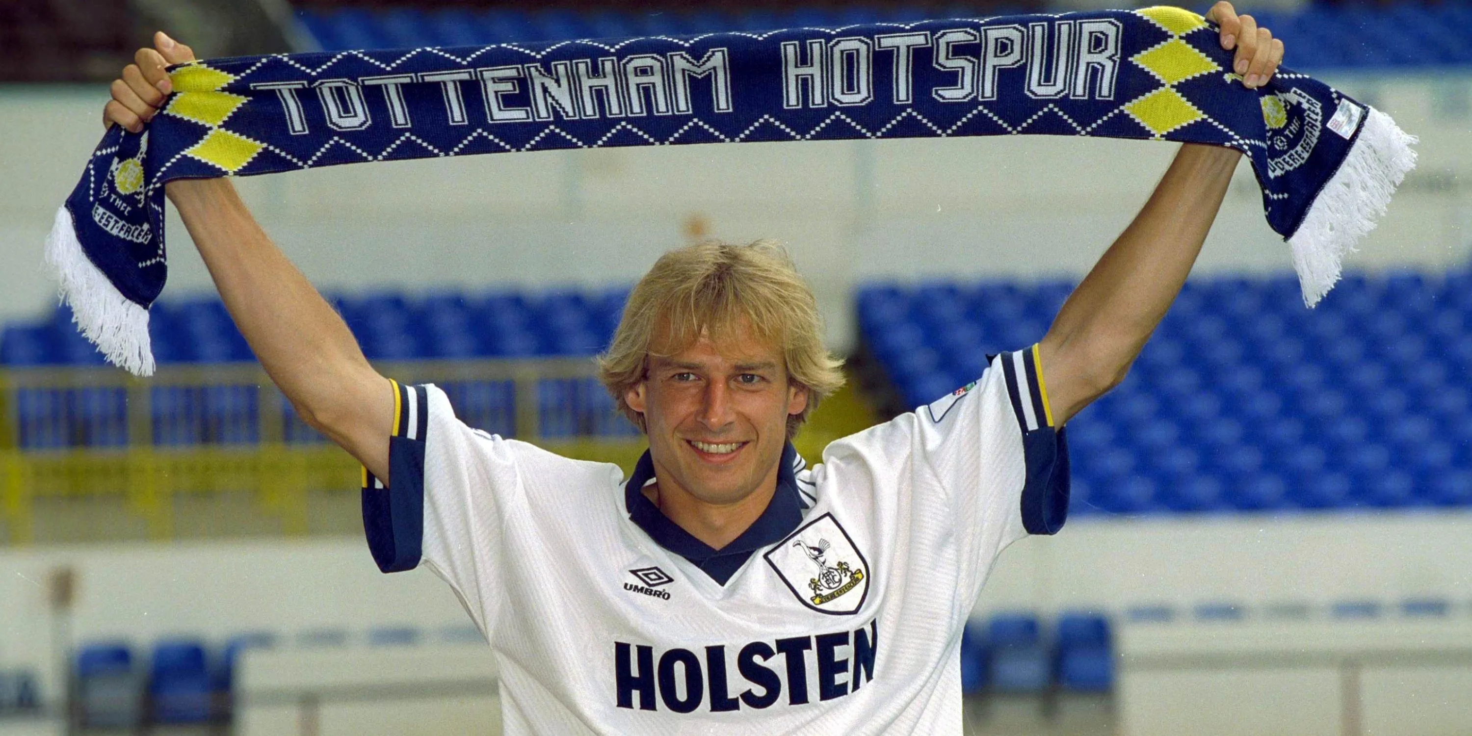 Jurgen Klinsmann giơ chiếc khăn Tottenham sau khi ký hợp đồng với câu lạc bộ.