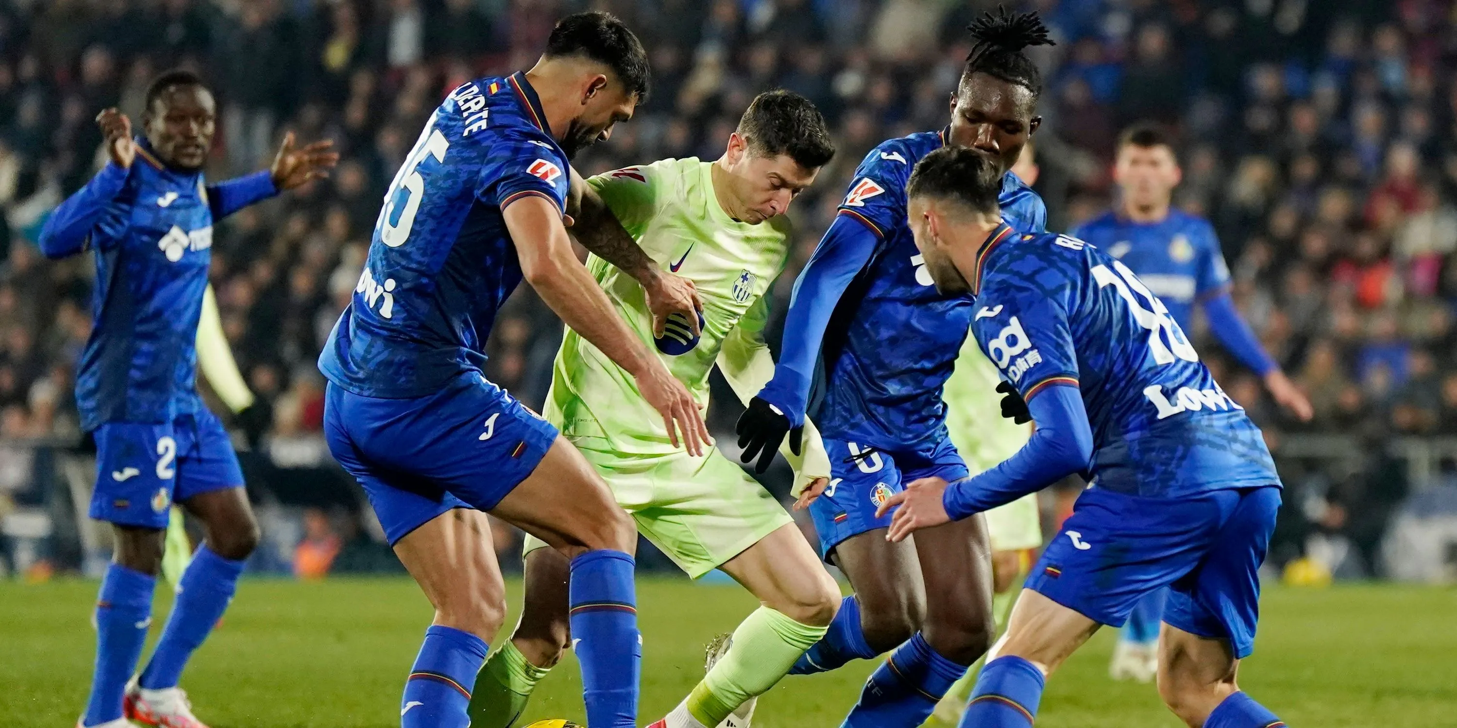 Tiền vệ Christantus Uche của Getafe đối đầu Robert Lewandowski của Barcelona trên sân cỏ La Liga